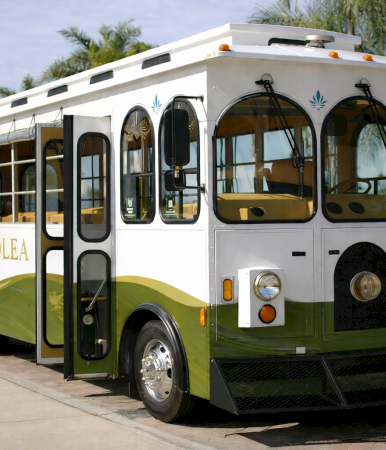 A vintage-style bus with white and green livery labeled &ldquo;Hotel Solea,&rdquo; rounded windows, and a front bumper&mdash;appears parked by the sidewalk.