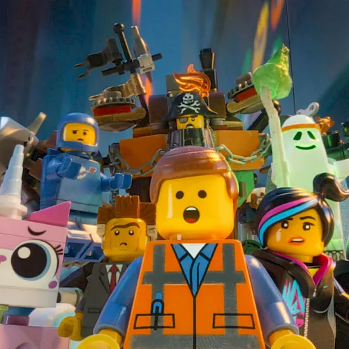 A crowd of LEGO-style characters in colorful armor and masks, including a pirate hat, cheering on stage.